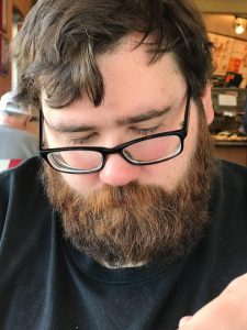 Photo of Matthew Marvin Distler [heavy set, bearded white male with brown hair and black rimmed eyeglasses]