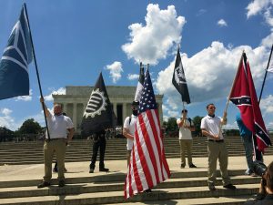 "Ajax" at the far left of the photo holding an Identity Evropa flag.