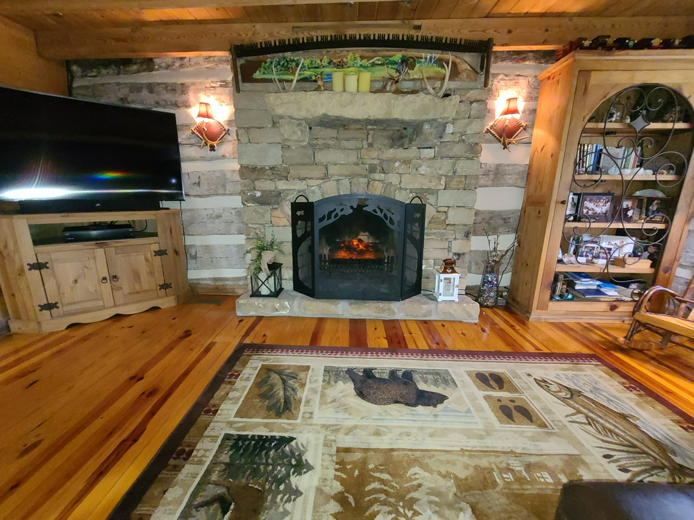 View of the living room from the online seller. Note that this is the same view as in the living room photo above, but this was before two windows were added to either side of the fireplace.