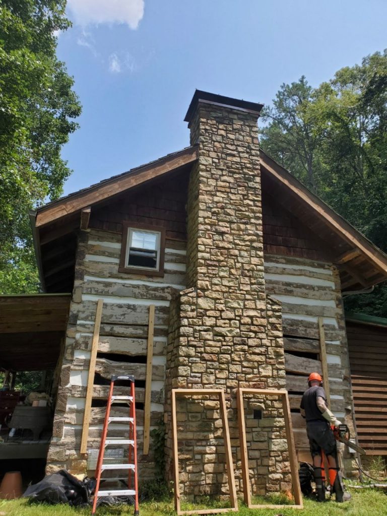 Ross Wainwright installing new windows in their Kentucky cabin.