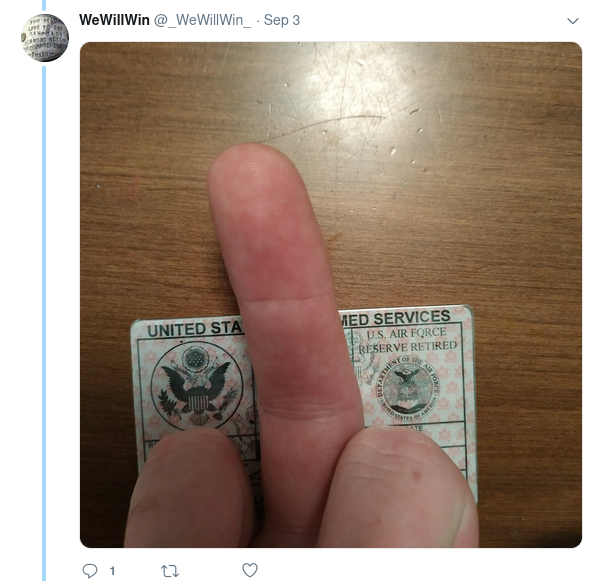[photo of a middle finger in front of a military ID card]