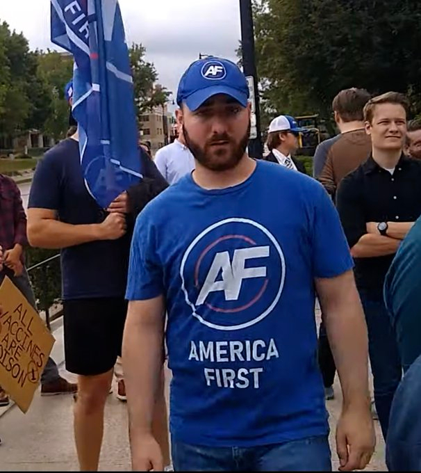 Joseph Brody wearing merchandise for Nicholas Fuentes' "America First" group at an event.